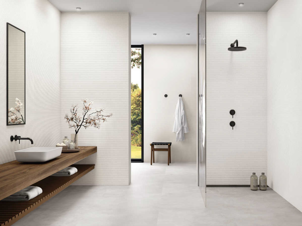 Espacio de baño con continuidad visual gracias a los azulejos de gran formato.